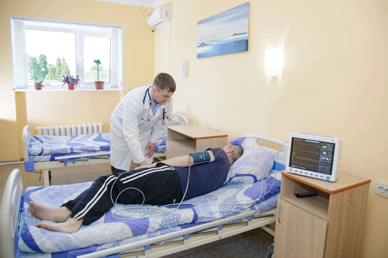 Лікар оглядає пацієнта в палаті, поруч монітор показників